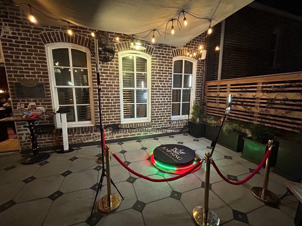 Jump King 360 video booth platform with lighting and red-rope stanchions