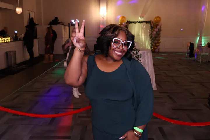A guest celebrating with photo booth props at an event